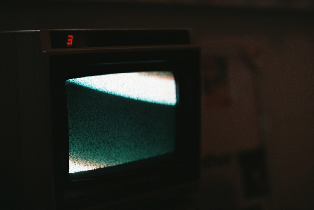 Oude CRT-televisie en verkleurd plastic onder warm lamplicht.