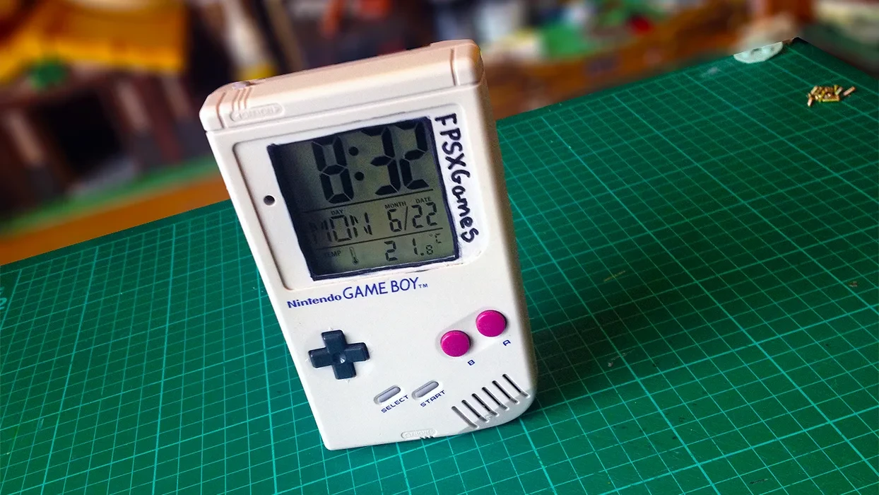 Een Game Boy cartridge op een houten lessenaar onder een bureaulamp.